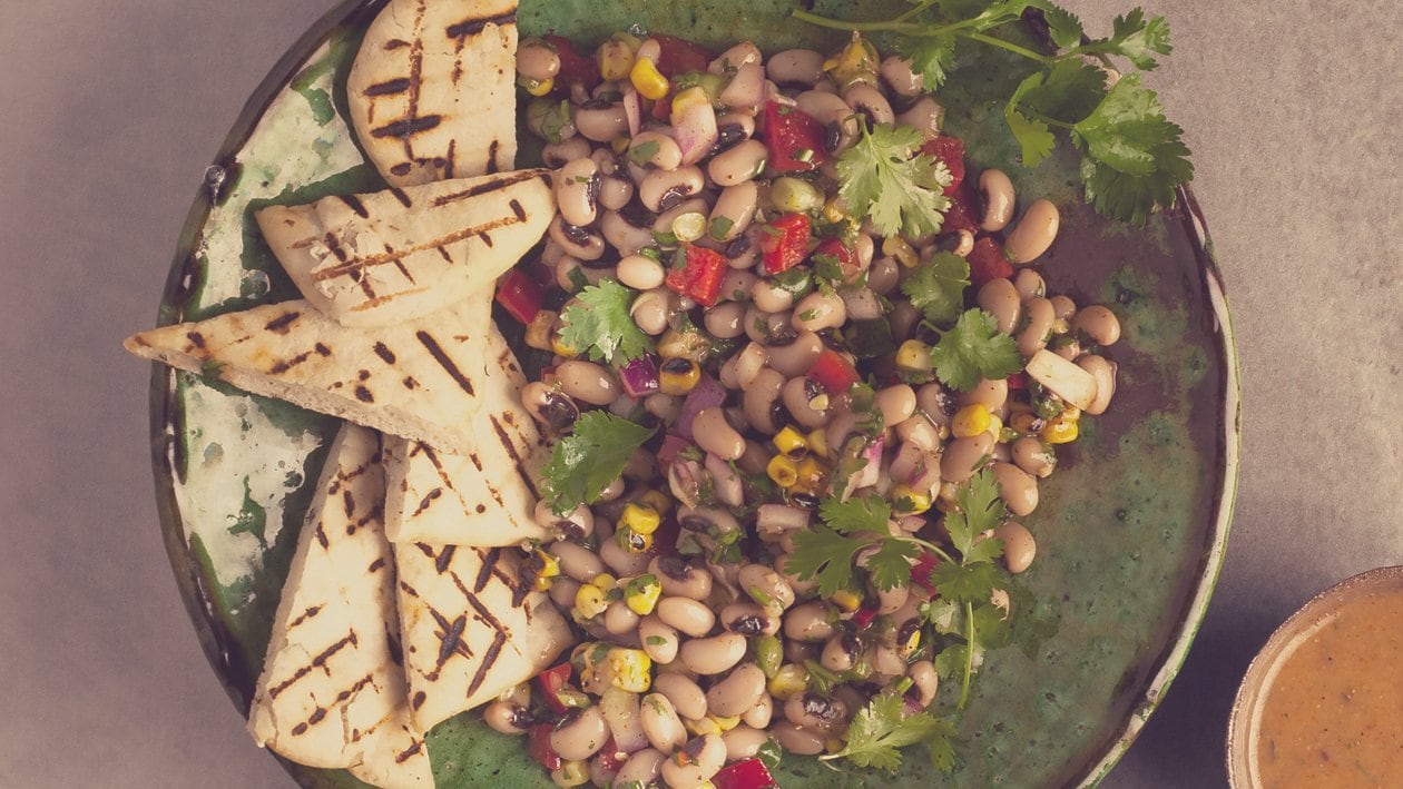 Salade van zwartoogbonen, geroostede pita, rode ui en dressing – - Recept 